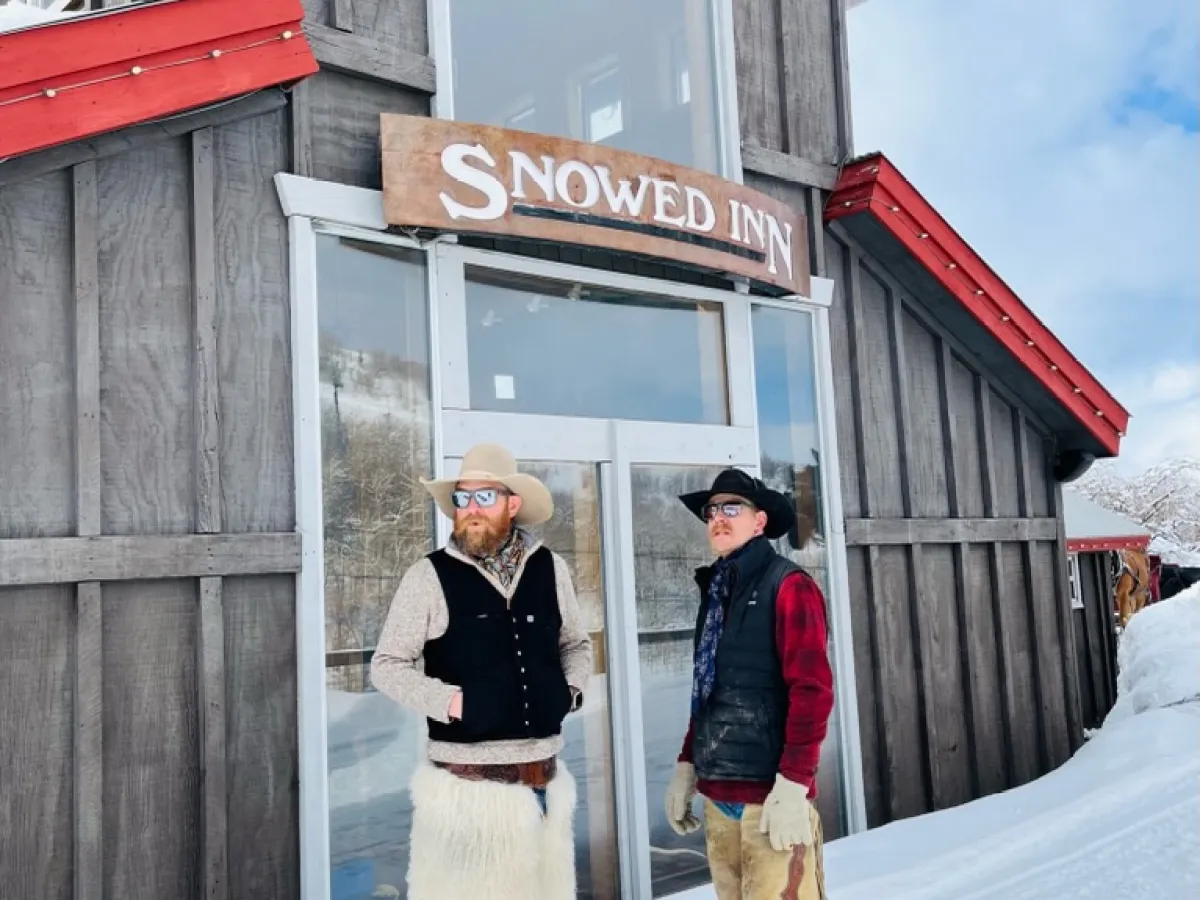 two cowboys standing next to a building