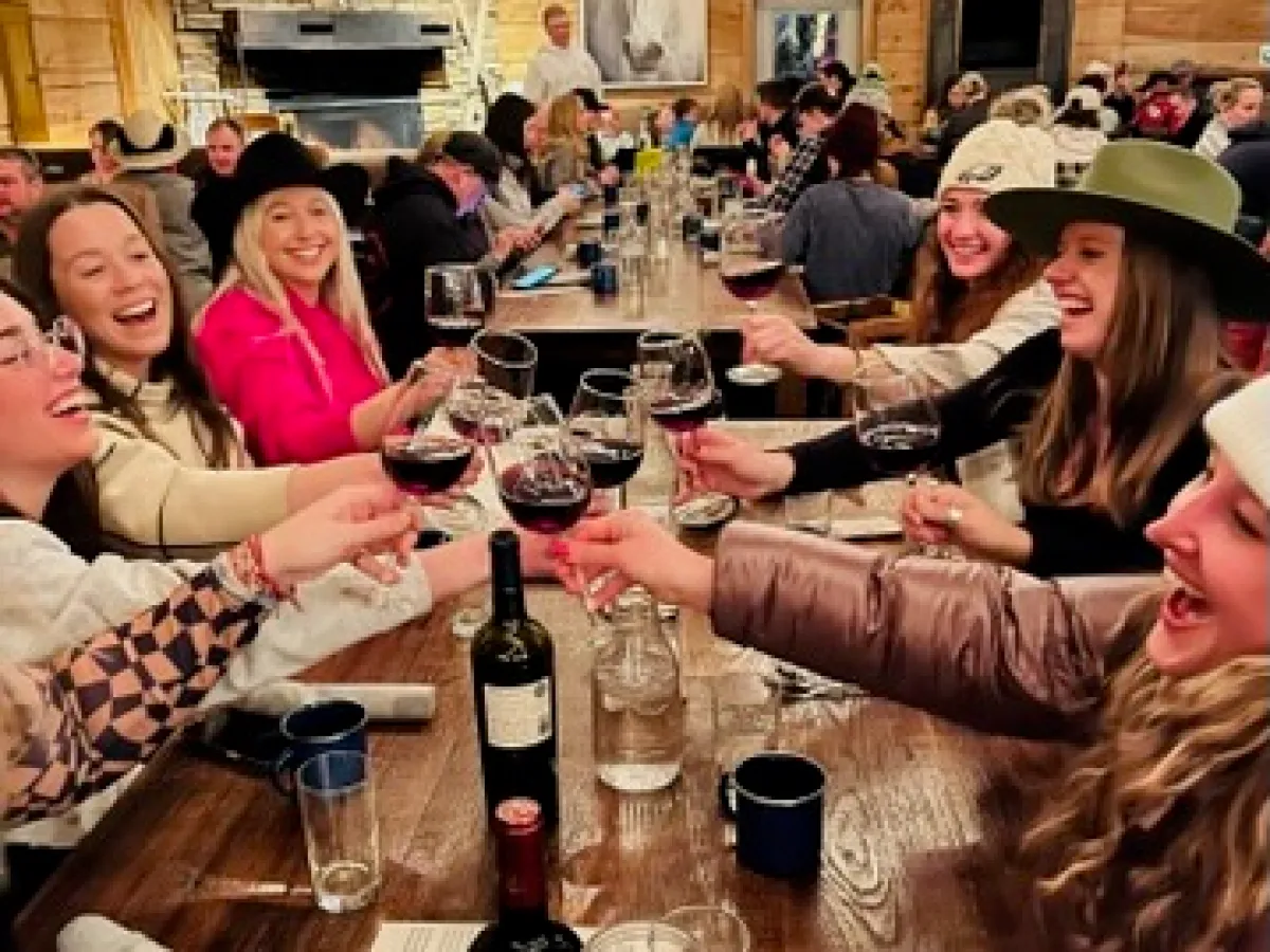 a group of people sitting at a table drinking wine